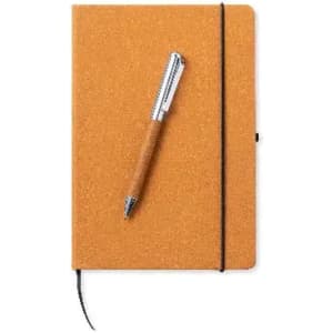 A notebook with an orange cork cover and a silver pen resting on top. It features an elastic closure.