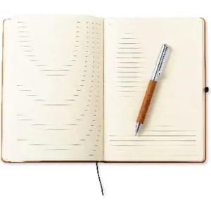 An open notebook with lined pages and a silver pen with a wooden handle resting on it.
