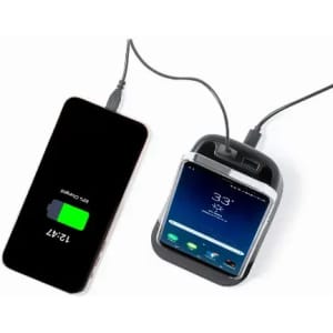 A charging station with a smartphone connected, displaying a battery percentage, set against a plain background.