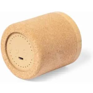 A cylindrical speaker with a cork exterior and a beige base, featuring a charging port and control buttons.