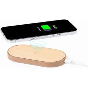 A wireless charger in a wooden finish next to a smartphone displaying a charging indicator.
