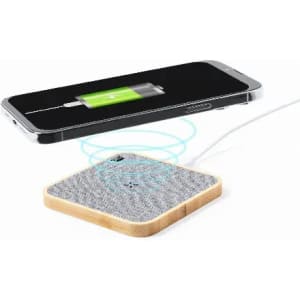 A wireless charger with a grey textured surface and wooden edges, compatible with smartphones.