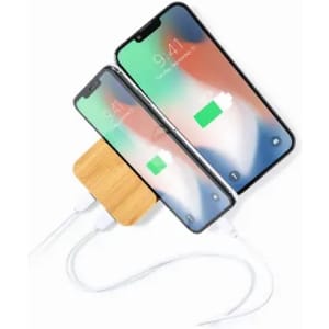 A magnetic wireless charger in a wooden casing, charging two smartphones simultaneously.