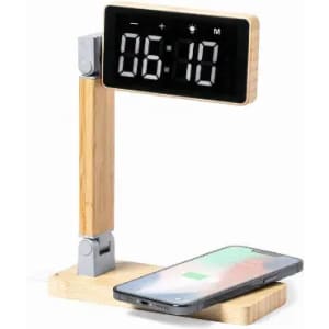 A digital clock with a wooden stand, displaying the time 06:10, beside a smartphone charging on a base.