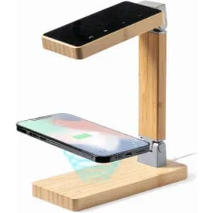 A desk lamp with a bamboo base and arm, featuring a wireless phone charging platform and touch controls on top.