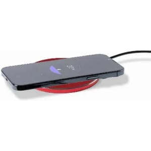 A wireless charging pad in red with a smartphone placed on top, connected via a charging cable.