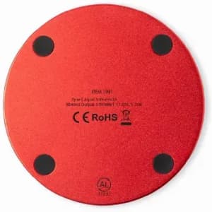 A circular red wireless charging pad with rubber feet on the bottom. It has a logo and certification markings.