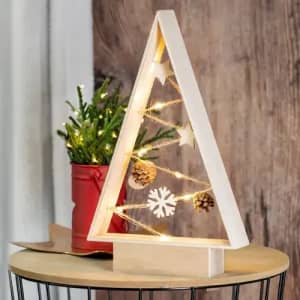 A decorative wooden Christmas tree with lights, adorned with stars, pinecones, and snowflakes, beside a small potted plant.