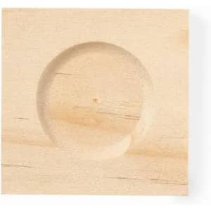 A wooden block with a round recessed area in the centre, showcasing a light natural wood finish.