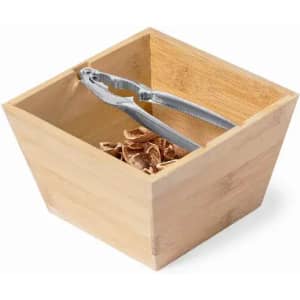 A wooden square container holds a pair of silver tongs and some brown objects inside.