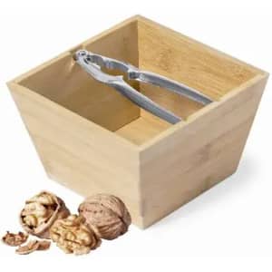 A wooden bowl with a stainless steel nutcracker inside, alongside cracked and whole walnuts.
