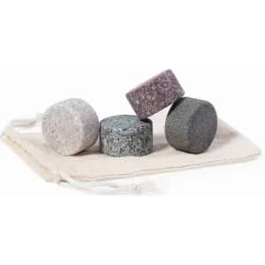 A set of four round stones in various shades, resting on a cloth pouch with drawstrings.