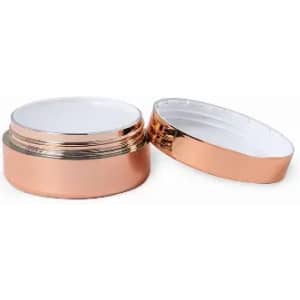 A rose gold container with a metallic finish and a removable lid, featuring a white interior.