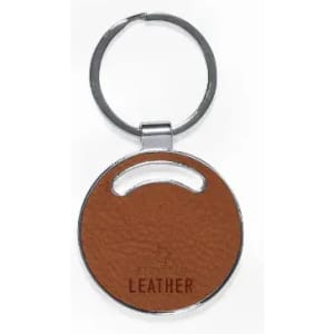A round keychain with a textured brown leather surface and a silver metal ring.
