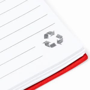 A notebook with lined pages and a red cover featuring a recycling symbol on the corner.