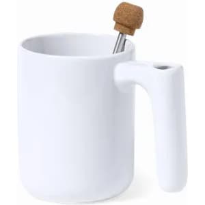 A white mug with a cork lid and a metal stirring stick. It features a unique handle design and a simple aesthetic.