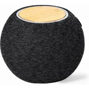 A round speaker with a black fabric exterior and a wooden top surface. It features a logo on the side.
