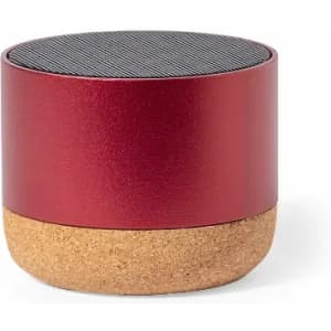 A round speaker featuring a red metallic top and a natural cork base. It has a simple and modern design.
