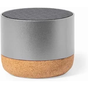 A cylindrical speaker in silver and cork, featuring a textured top and a smooth base. It includes a logo.
