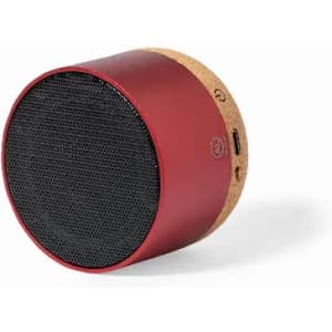A portable speaker in red with a cork base, featuring a mesh front and side charging port.