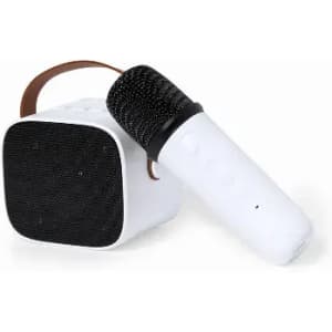 A white microphone sits next to a compact speaker with a dark mesh front and a brown strap.