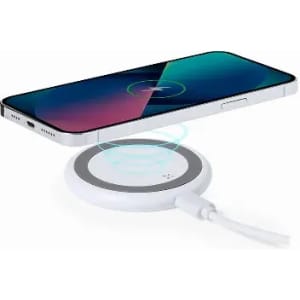 A wireless charger in white with a smartphone above it, displaying a charging icon on the screen.