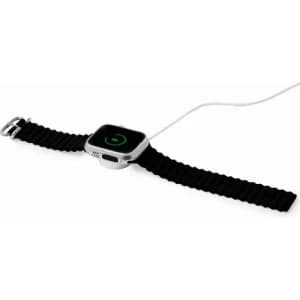 A smartwatch with a black band connected to a charging cable, displaying a green charging icon.