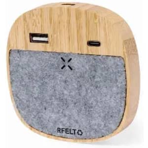 A wooden speaker with a grey felt front, featuring USB and USB-C ports. It has a logo on the base.