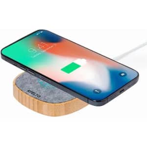 A wireless charger with a wooden base and a smartphone displaying a charging icon.