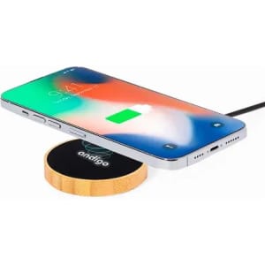 A wireless charging pad with a wooden base and a smartphone placed on top, showing a charging indicator.
