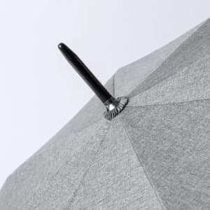 A grey umbrella with a black handle, featuring a textured fabric design. It has a central pin for opening and closing.
