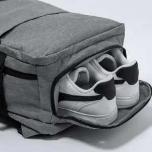 A grey bag with a separate compartment containing white sneakers with black accents.