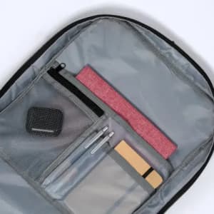 A grey backpack pocket containing pens, a notebook, and a mesh pouch with small items.