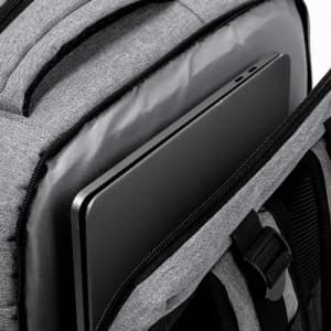 A grey backpack with a laptop partially visible in the main compartment. It features padded straps and a sleek design.
