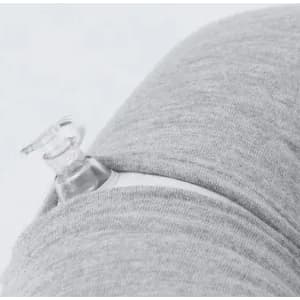 A clear drink bottle nestled in the fabric of grey clothing, featuring a minimalistic design and a logo.