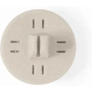 A round, light beige product with a central protrusion and multiple grooves around the edge, featuring a simple design.