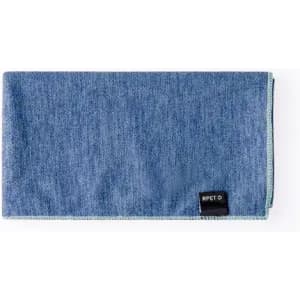 A blue fabric item with a textured appearance and a tag sewn onto the edge, featuring a logo.