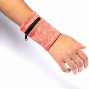 A red wristband with a zippered pocket, designed to be worn on the wrist. It features a textured fabric.