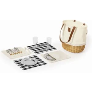 A picnic set featuring a woven basket, checkered placemats, plates, glasses, and cutlery in a cream and black colour scheme.
