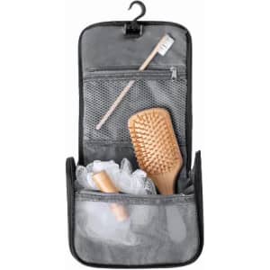 A toiletry bag in black, containing a wooden hairbrush, a toothbrush, and travel-sized bottles. It has a hanging hook.