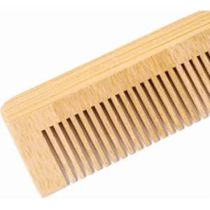 A wooden comb with a light brown finish, featuring fine and wide teeth. The comb has a distinctive, smooth texture.
