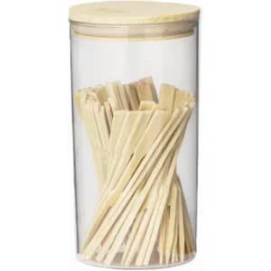 A clear jar with a wooden lid, containing numerous wooden sticks arranged vertically inside.