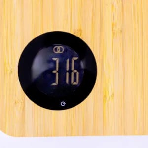 A bamboo kitchen scale with a digital display showing the weight as 316. The scale features a round black interface.