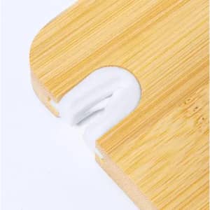 A bamboo cutting board with a white silicone grip. The board has rounded edges and a small cut-out for handling.