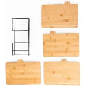A set of four bamboo cutting boards in different sizes with a black metal storage rack.