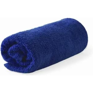 A rolled navy blue towel, soft and fluffy, positioned on a white background. It has no visible logos or text.
