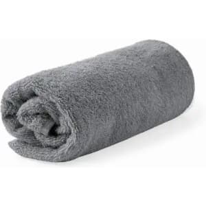 A rolled grey towel made of soft, plush fabric, showcasing a smooth texture. It has a simple, elegant design.