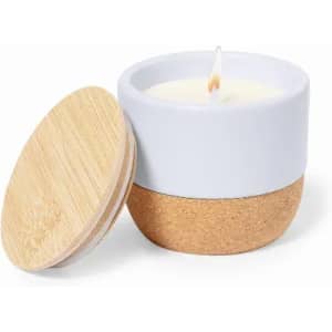 A candle in a two-tone container with a white top, cork bottom, and a wooden lid. The wick is lit.