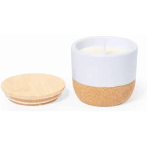 A candle in a white and cork holder, accompanied by a separate wooden lid. The design is simple and modern.