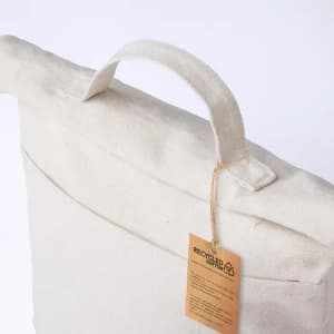 A tote bag in cream colour made from recycled cotton, featuring a handle and a tag.